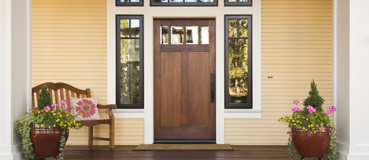 Entry door and yellow siding on house.