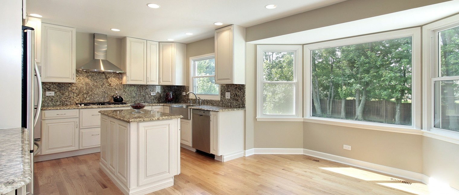 Open lit kitchen with windows.