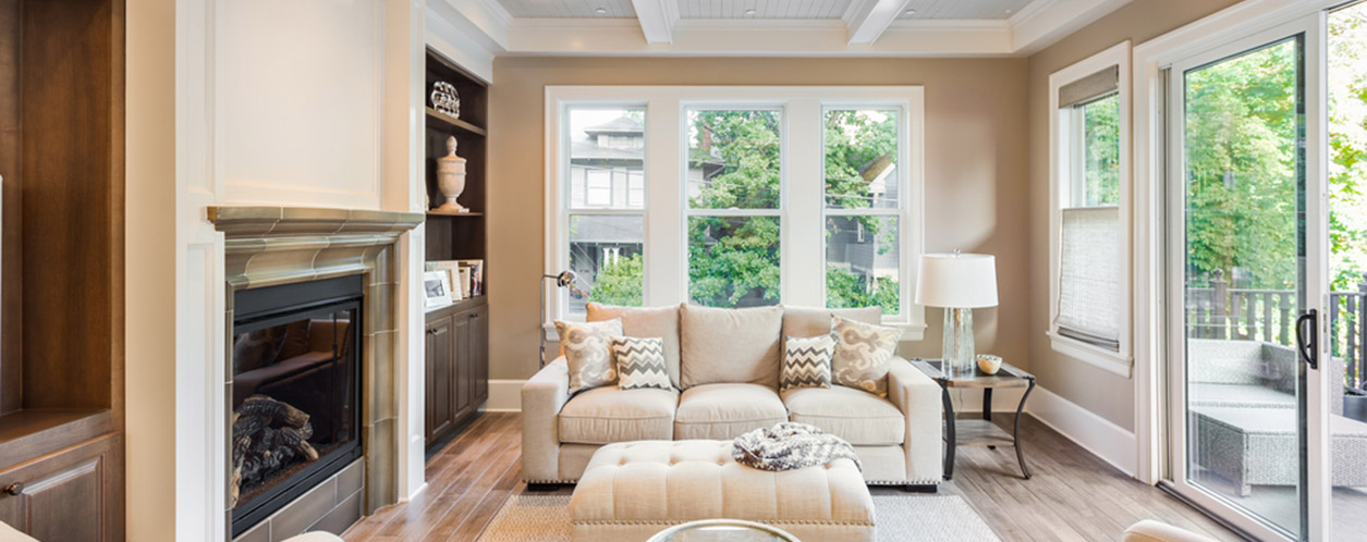 A well lit living room with beige furniture.