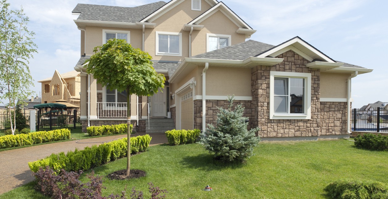 Brand new suburban house in sunny summer afternoon with custom pvc windows.