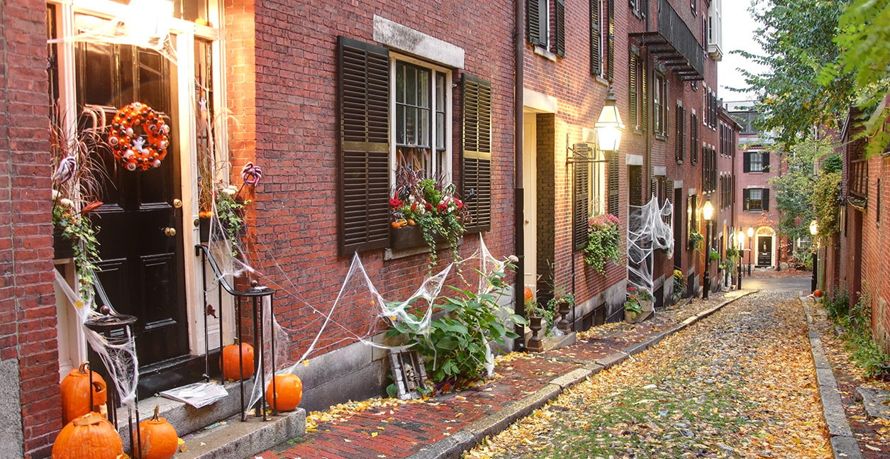 A view of houses with halloween decorations on their windows and doors.