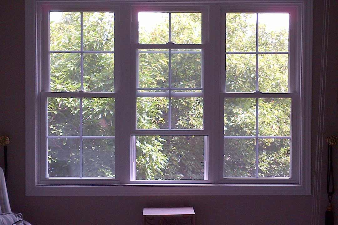 An interior of a home with three double hung windows.