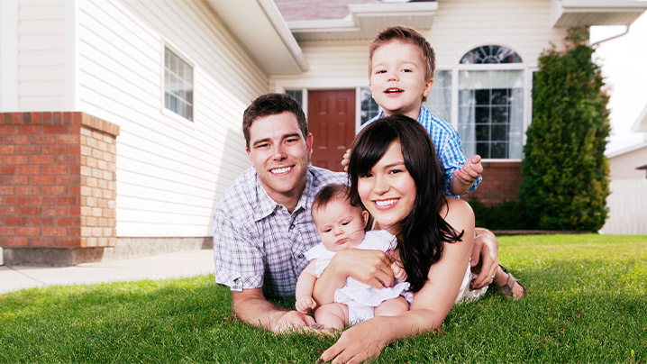 A family laying on the grass.