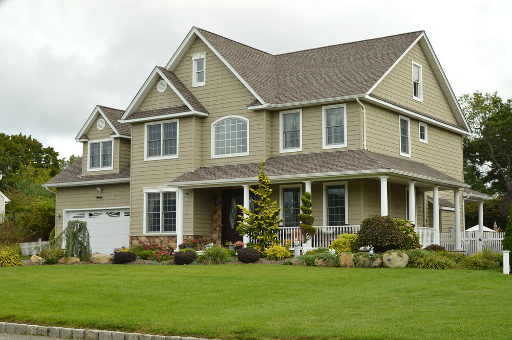 Green siding house with custom gable vents and window and door trim.