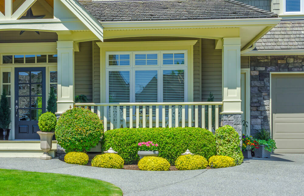 A house with custom window trim and a modern steel entry door.