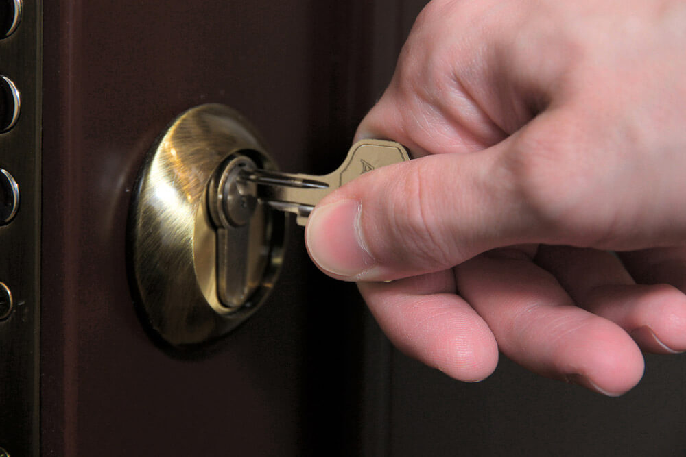 Key being inserted into steel entry door hardware