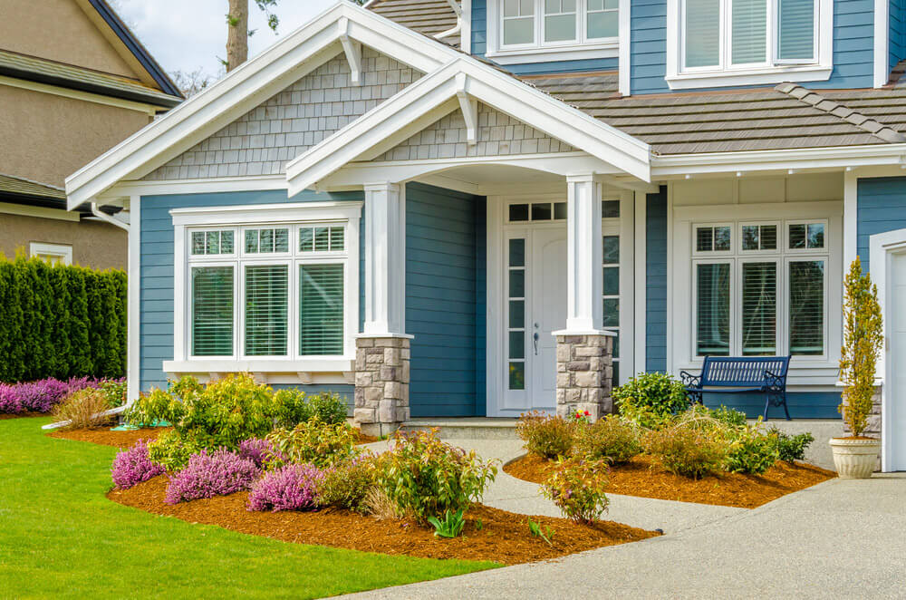 A modern blue home with custom siding and brand eavestrough and fascia.
